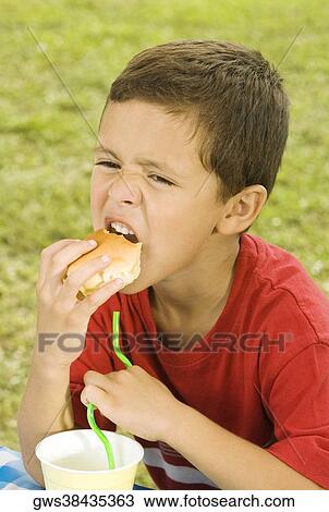 Close-up of a boy eating a burger View Large Photo Image Stock Image - Close-up of a boy eating a burger. Fotosearch