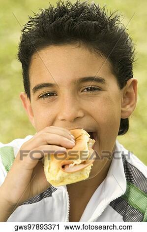 Close-up of a boy eating a burger View Large Photo Image Stock Image - Close-up of a boy eating a burger. Fotosearch