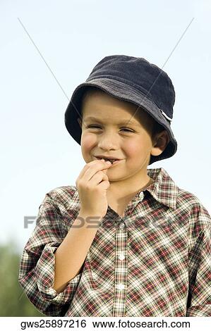 Close-up of a boy eating a chocolate View Large Photo Image Stock Photograph - Close-up of a boy eating a chocolate. Fotosearch