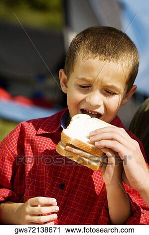 Close-up of a boy eating a sandwich View Large Photo Image Stock Image - Close-up of a boy eating a sandwich. Fotosearch