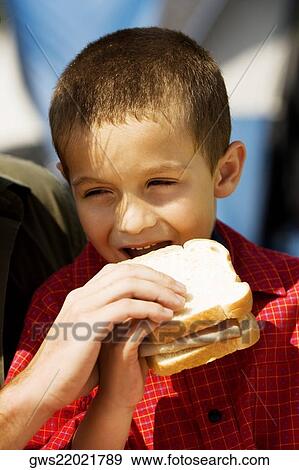 Close-up of a boy eating a sandwich View Large Photo Image Stock Photo - Close-up of a boy eating a sandwich. Fotosearch