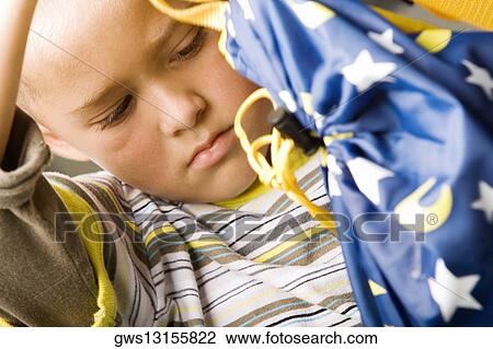 Stock Image - Close-up of a boy holding a bag. Fotosearch