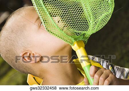 Close-up of a boy holding a butterfly net View Large Photo Image Stock Photo - Close-up of a boy holding a butterfly net. Fotosearch