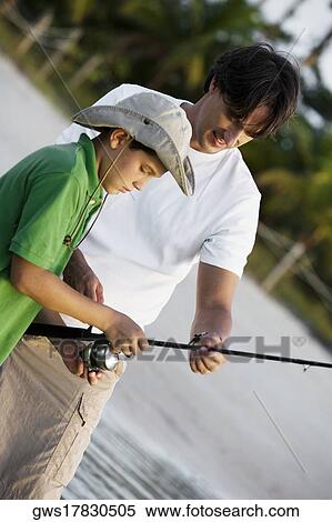 Close-up of a boy holding a fishing rod with his father View Large Photo Image Stock Photography - Close-up of a boy holding a fishing rod with his father. Fotosearch
