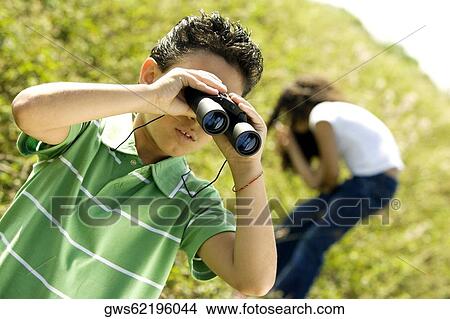 Close-up of a boy looking through a pair of binoculars View Large Photo Image Picture - Close-up of a boy looking through a pair of binoculars. Fotosearch