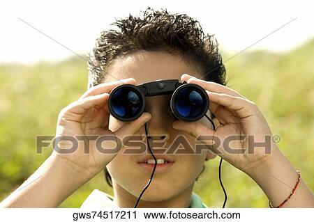 Close-up of a boy looking through a pair of binoculars View Large Photo Image Stock Image - Close-up of a boy looking through a pair of binoculars. Fotosearch