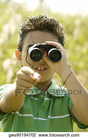 Close-up of a boy looking through a pair of binoculars View Large Photo Image Stock Image - Close-up of a boy looking through a pair of binoculars. Fotosearch