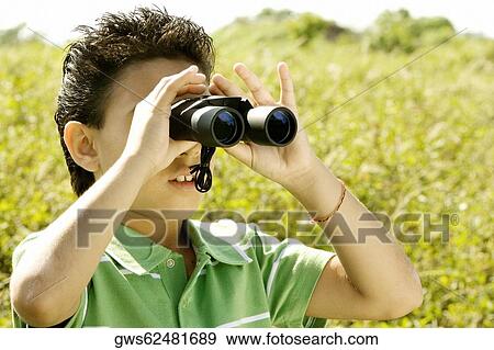 Close-up of a boy looking through a pair of binoculars View Large Photo Image Stock Photo - Close-up of a boy looking through a pair of binoculars. Fotosearch