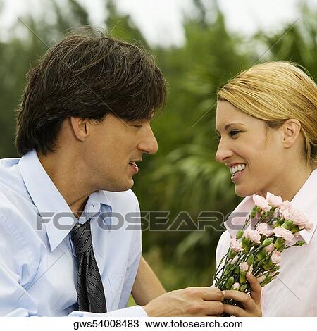 Close-up of a businessman and a businesswoman looking at each other in the park View Large Photo Image Stock Image - Close-up of a businessman and a businesswoman looking at each other in the park. Fotosearch