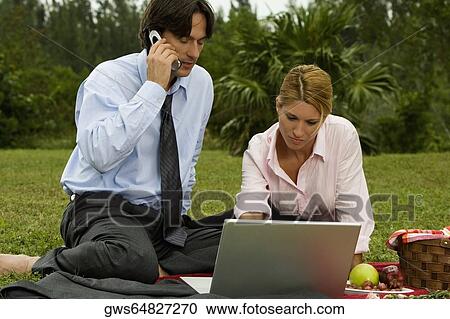 Close-up of a businessman and a businesswoman working on a laptop View Large Photo Image Stock Image - Close-up of a businessman and a businesswoman working on a laptop. Fotosearch