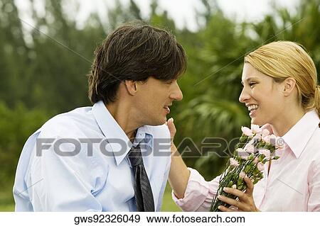 Close-up of a businessman and a businesswoman looking at each other in the park View Large Photo Image Stock Photo - Close-up of a businessman and a businesswoman looking at each other in the park. Fotosearch