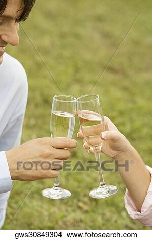 Close-up of a businessman and a woman toasting with champagne flutes View Large Photo Image Picture - Close-up of a businessman and a woman toasting with champagne flutes. Fotosearch