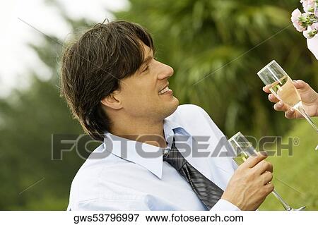 Close-up of a businessman and a woman holding champagne flutes View Large Photo Image Stock Photo - Close-up of a businessman and a woman holding champagne flutes. Fotosearch