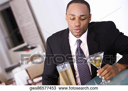 Close-up of a businessman holding a glass of martini View Large Photo Image Stock Image - Close-up of a businessman holding a glass of martini. Fotosearch