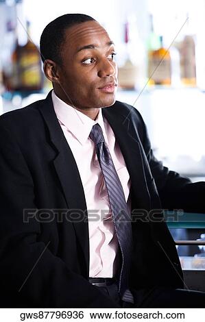 Close-up of a businessman in a bar View Large Photo Image Stock Photograph - Close-up of a businessman in a bar. Fotosearch