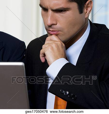 Stock Photograph - Close-up of a businessman working on a laptop. Fotosearch
