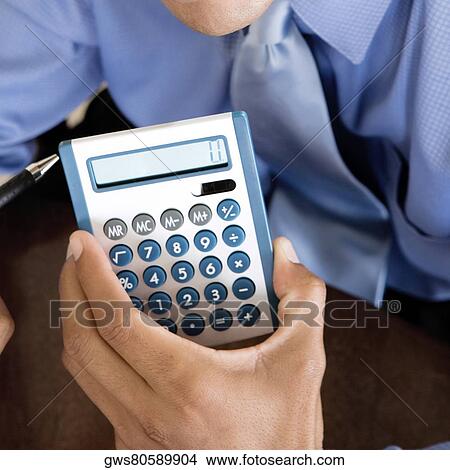 Close-up of a businessman's hand holding a calculator View Large Photo Image Picture - Close-up of a businessman's hand holding a calculator. Fotosearch
