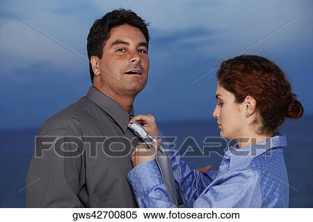 Close-up of a businesswoman adjusting the tie of a businessman View Large Photo Image Stock Photography - Close-up of a businesswoman adjusting the tie of a businessman. Fotosearch