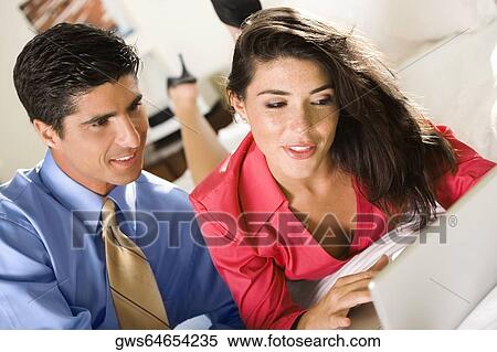 Close-up of a businesswoman and a businessman using a laptop View Large Photo Image Stock Photography - Close-up of a businesswoman and a businessman using a laptop. Fotosearch