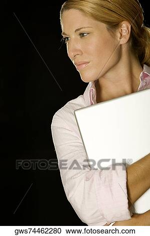 Close-up of a businesswoman holding a laptop View Large Photo Image Stock Image - Close-up of a businesswoman holding a laptop. Fotosearch