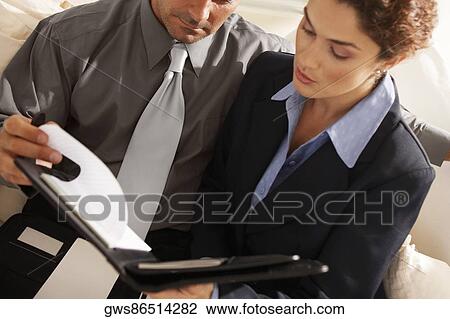 Close-up of a businesswoman with a businessman holding a file View Large Photo Image Stock Image - Close-up of a businesswoman with a businessman holding a file. Fotosearch