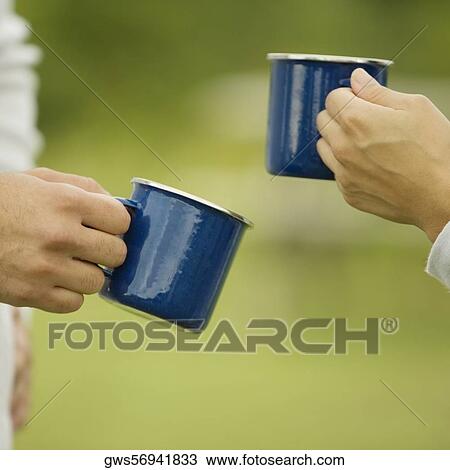 Close-up of a couple's hand holding two cups View Large Photo Image Stock Image - Close-up of a couple's hand holding two cups. Fotosearch