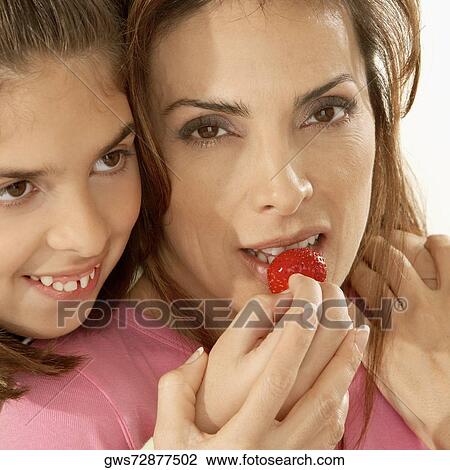 Close-up of a daughter feeding her mother a strawberry View Large Photo Image Stock Image - Close-up of a daughter feeding her mother a strawberry. Fotosearch