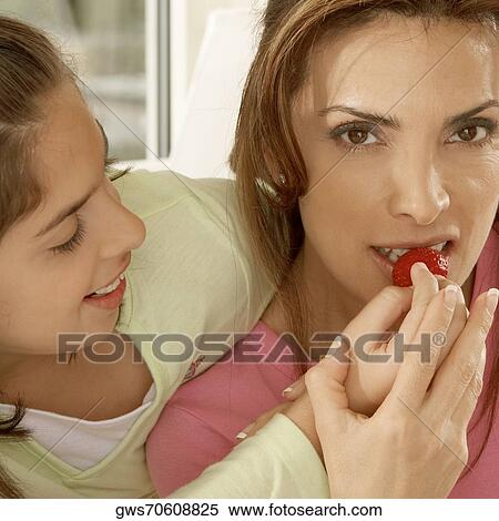 Close-up of a daughter feeding her mother a strawberry View Large Photo Image Stock Photography - Close-up of a daughter feeding her mother a strawberry. Fotosearch