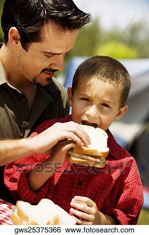 Close-up of a father feeding his son a sandwich View Large Photo Image Stock Photograph - Close-up of a father feeding his son a sandwich. Fotosearch