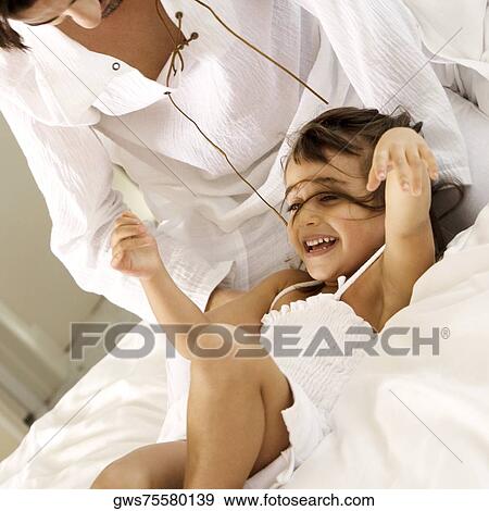 Close-up of a father tickling his daughter View Large Photo Image Stock Photo - Close-up of a father tickling his daughter. Fotosearch