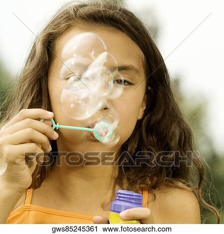 Close-up of a girl blowing bubbles with a bubble wand View Large Photo Image Stock Image - Close-up of a girl blowing bubbles with a bubble wand. Fotosearch