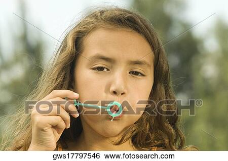 Close-up of a girl blowing bubbles with a bubble wand View Large Photo Image Stock Photograph - Close-up of a girl blowing bubbles with a bubble wand. Fotosearch