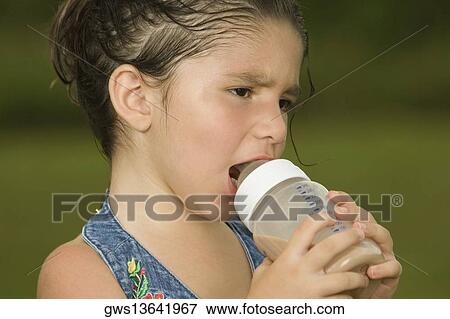 Close-up of a girl holding a baby bottle View Large Photo Image Stock Photo - Close-up of a girl holding a baby bottle. Fotosearch