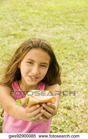 Stock Photography - Close-up of a girl holding a burger. Fotosearch