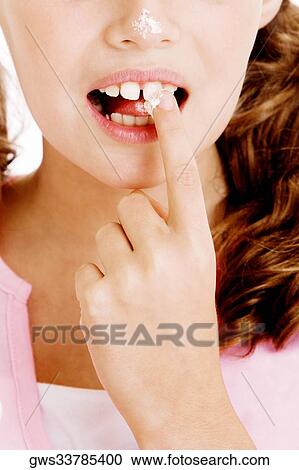 Close-up of a girl holding a sugar cube between her teeth View Large Photo Image Stock Image - Close-up of a girl holding a sugar cube between her teeth. Fotosearch