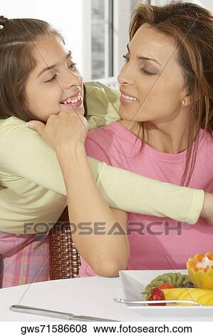 Close-up of a girl hugging her mother View Large Photo Image Stock Photo - Close-up of a girl hugging her mother. Fotosearch