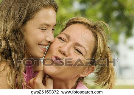 Close-up of a girl kissing her mother View Large Photo Image Stock Image - Close-up of a girl kissing her mother. Fotosearch