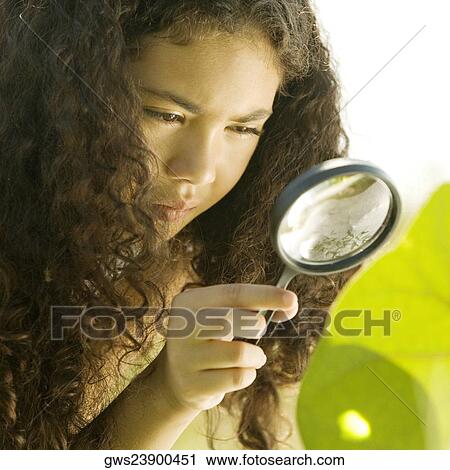 Close-up of a girl looking through a magnifying glass View Large Photo Image Stock Image - Close-up of a girl looking through a magnifying glass. Fotosearch