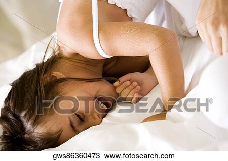 Close-up of a girl lying on the bed smiling View Large Photo Image Stock Image - Close-up of a girl lying on the bed smiling. Fotosearch