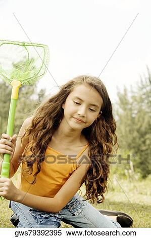 Stock Photography - Close-up of a girl sitting holding a butterfly net. Fotosearch
