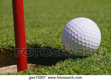 Close-up of a golf ball at the edge of hole View Large Photo Image Stock Photo - Close-up of a golf ball at the edge of hole. Fotosearch
