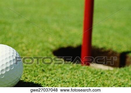 Close-up of a golf ball near a hole View Large Photo Image Stock Photo - Close-up of a golf ball near a hole. Fotosearch