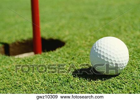 Close-up of a golf ball near a hole View Large Photo Image Stock Photo - Close-up of a golf ball near a hole. Fotosearch