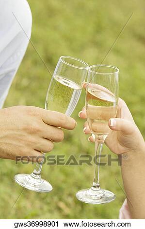 Close-up of a man and a woman toasting champagne flutes View Large Photo Image Stock Image - Close-up of a man and a woman toasting champagne flutes. Fotosearch