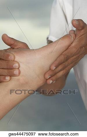 Close-up of a man massaging a person's foot View Large Photo Image Stock Photo - Close-up of a man massaging a person's foot. Fotosearch