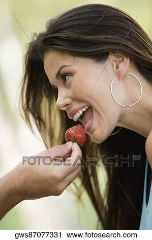 Close-up of a man's hand feeding a young woman a strawberry View Large Photo Image Stock Image - Close-up of a man's hand feeding a young woman a strawberry. Fotosearch