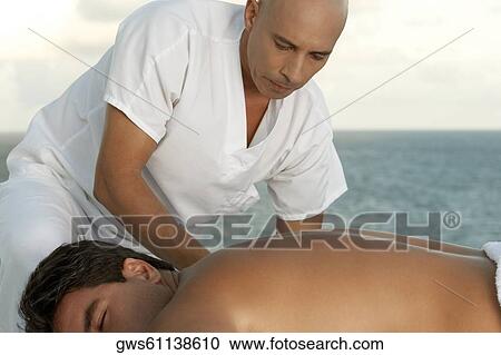 Close-up of a massage therapist massaging a mid adult man's back View Large Photo Image Stock Image - Close-up of a massage therapist massaging a mid adult man's back. Fotosearch
