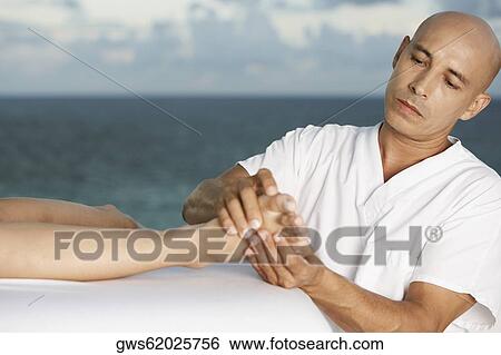 Close-up of a massage therapist massaging a person's foot View Large Photo Image Stock Photograph - Close-up of a massage therapist massaging a person's foot. Fotosearch