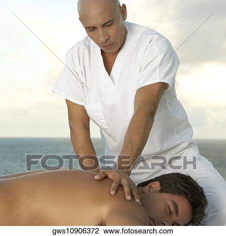 Close-up of a mature man giving a mid adult man a back massage View Large Photo Image Stock Image - Close-up of a mature man giving a mid adult man a back massage. Fotosearch