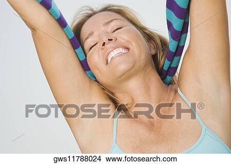 Close-up of a mature woman smiling with her arms raised View Large Photo Image Picture - Close-up of a mature woman smiling with her arms raised. Fotosearch